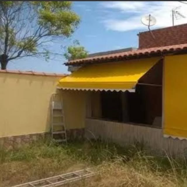 Toldo amarelo sobre janela em fachada amarela