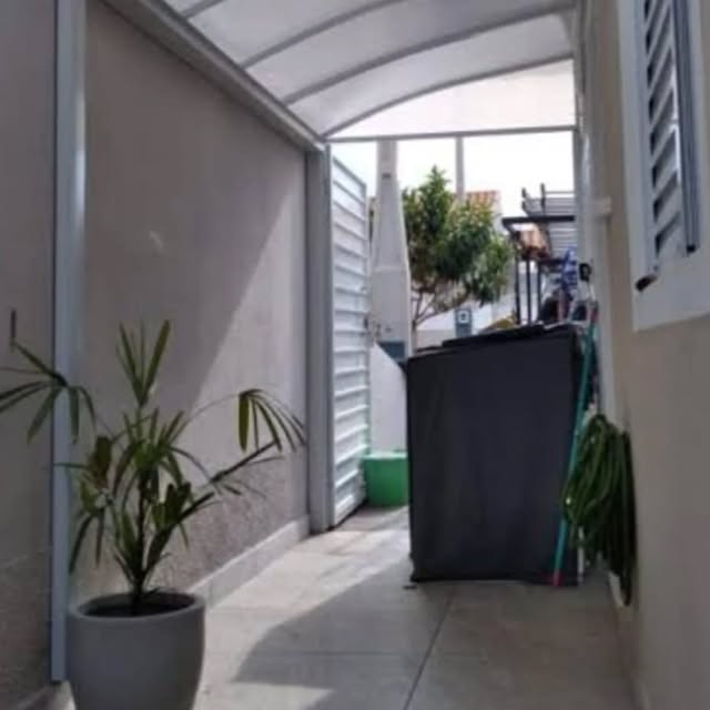 Toldo lateral cinza junto a um corredor coberto